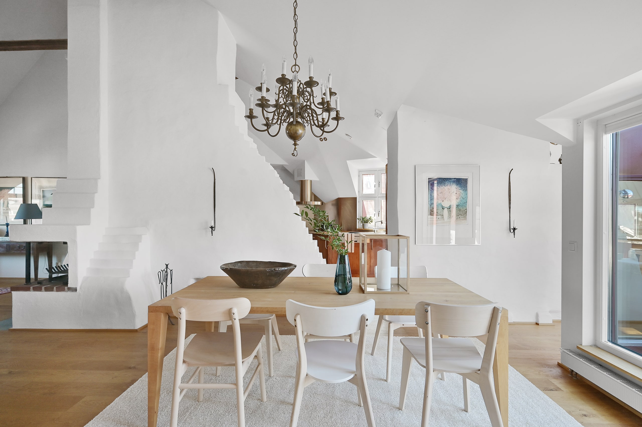 Ljus matsal med mässingskrona och ekbord